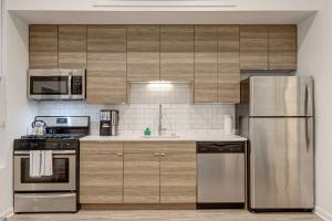 a kitchen with wooden cabinets and stainless steel appliances at Cabin 105 by 747 Lofts in Chicago