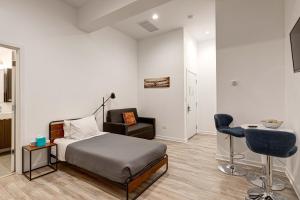 ein Schlafzimmer mit einem Bett, einem Stuhl und einem Schreibtisch in der Unterkunft Cabin 105 by 747 Lofts in Chicago