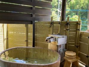 y baño con bañera grande de madera. en Katsura no Izumi, en Izunokuni