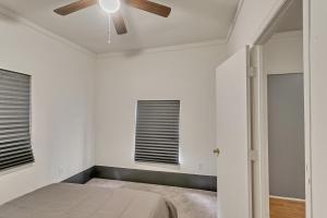 a bedroom with a ceiling fan and two windows at Cozy charming two-story home great for long stays home in Savannah