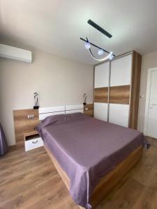 a bedroom with a bed with a purple blanket at Apartment Veronika in Sozopol