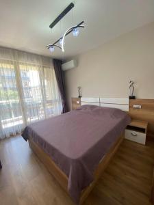 a bedroom with a large bed and a large window at Apartment Veronika in Sozopol +2 photos