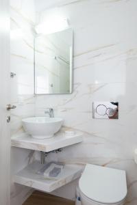 Baño blanco con lavabo y aseo en Hotel Sofia, en Apollonia