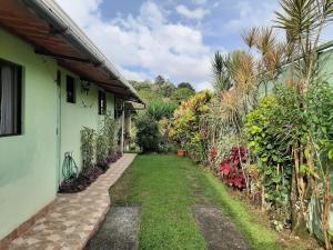 einen Gartenweg, der zu einem Haus führt in der Unterkunft Marita's Bed and Breakfast in Nuevo Arenal