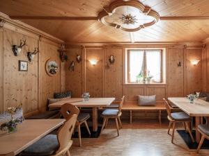 un ristorante con pareti e tavoli in legno e un lampadario a braccio di Hotel B&B Martha a Brunico