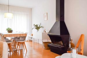 a living room with a fireplace and a dining table at Can Falga Alojamiento en el corazón de Besalú in Besalú