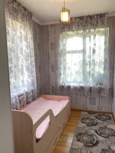 a small bedroom with a bed and a window at Guest House ak orgo in Bishkek