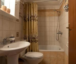 a bathroom with a sink and a toilet and a tub at Antique Apartment in Afitos +20 photos