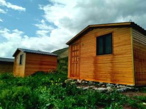 a couple of wooden buildings sitting in a field at Eco Aura (RestZone) in Areguni