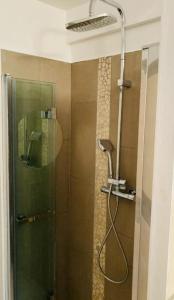 W łazience znajduje się prysznic ze szklanymi drzwiami. w obiekcie Le Jardin de Pierrefeu w mieście Caseneuve