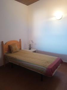 Schlafzimmer mit einem Bett und einer Lampe auf einem Tisch in der Unterkunft Casita con vista a la montaña in Icod de los Vinos