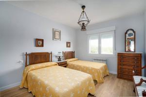 1 dormitorio con 2 camas, vestidor y ventana en MyHouseSpain - La Atalaya, casa frente al mar, 