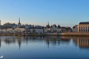 a view of a city with a river and buildings at CyclodeLoire vue splendide in Saumur