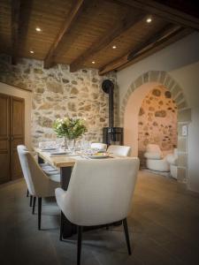 Venez Chez Vous - La Grange du Lac - Vue montagne في سان جوريوز: غرفة طعام مع طاولة وكراسي بيضاء