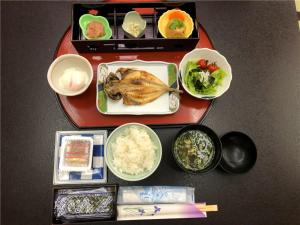 una mesa con un plato de comida y tazones de comida en Katsura no Izumi, en Izunokuni