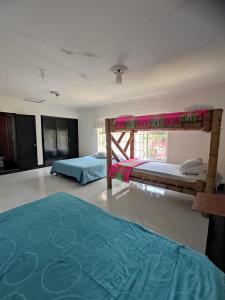 a bedroom with two bunk beds and a green rug at Hotel Centro Recreacional Valle deEli in Fusagasuga