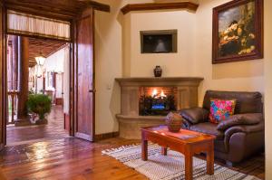 sala de estar con sofá y chimenea en Hotel Casa del Naranjo, en Pátzcuaro