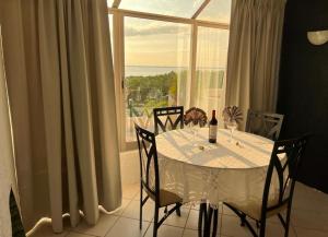 a table with chairs and a white table and a window at Solymar Condos in Cancún