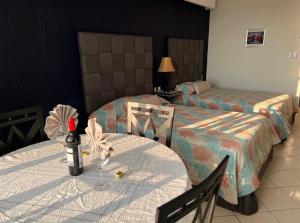 a hotel room with two beds and a bottle of wine on a table at Solymar Condos in Cancún