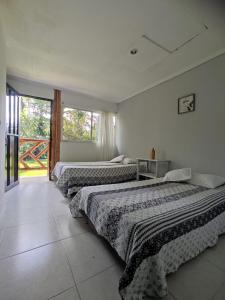 a bedroom with two beds and a large window at Hotel Centro Recreacional Valle deEli in Fusagasuga