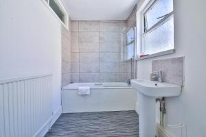 ein Badezimmer mit einem Waschbecken und einer Badewanne in der Unterkunft StayRight 2 Bed Central Flat- 10 mins walk to Castle & Centre in Cardiff