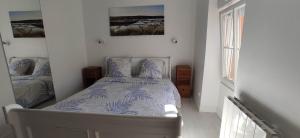 a bedroom with a bed with a blue and white comforter at Centre ville à 2 pas de la plage in Pornichet