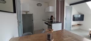 a kitchen with a sink and a refrigerator and a table at Centre ville à 2 pas de la plage in Pornichet