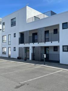 um parque de estacionamento vazio em frente a um edifício branco em Saga Apartments Reykjavík em Reykjavík