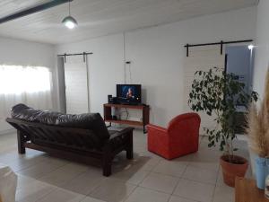 a living room with a couch and a red chair at El séptimo día, lugar de descanso in Funes