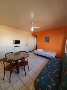 sala de estar con mesa y cama en Residencial Salinas, en Florianópolis
