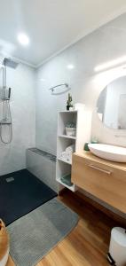 ein Bad mit einem Waschbecken und einem Spiegel in der Unterkunft Au Doux Refuge in Le Lambert