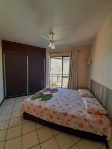 1 dormitorio con cama y ventana grande en Residencial Salinas, en Florianópolis