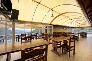 ein Restaurant mit Holztischen und -stühlen und Aussicht in der Unterkunft La Cicala 1 in Stellanello