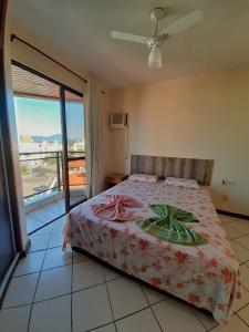 1 dormitorio con 1 cama y balcón con vistas. en Residencial Salinas, en Florianópolis