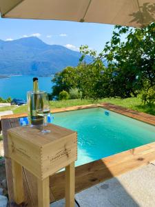 een glas wijn op een tafel naast een zwembad bij Grandin Holidayhouse in Domaso