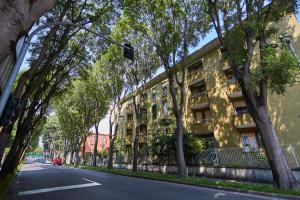 eine von Bäumen gesäumte Straße vor einem Gebäude in der Unterkunft MONZA-MILANO - Comfort tra centro e stazione - WIFI in Monza