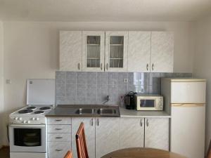 a kitchen with white cabinets and a sink and a microwave at Guest House Šobić in Šipovo +76 photos