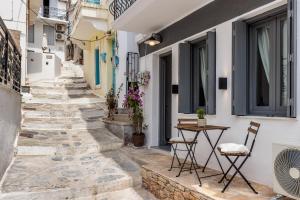 eine Straße in Opitano mit einem Tisch und Stühlen in der Unterkunft The Grey Home in Skopelos