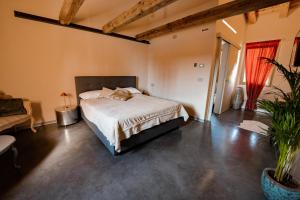 1 dormitorio con cama, sofá y planta en Bed & Breakfast Gioia di..., en Santo Stino di Livenza