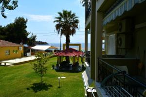 a balcony with a gazebo and a palm tree at Chrissi Ammoudia in Toroni