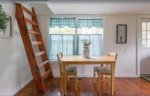una sala da pranzo con tavolo, sedie e scala di A Mountain Cottage cabin a Sevierville Altre 21 foto