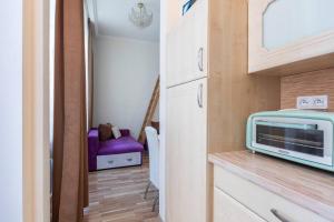 a kitchen with a microwave and a purple couch at Apartment on Masaryka 39 in Karlovy Vary