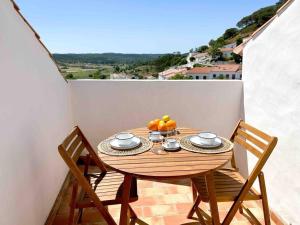 un tavolo in legno con un cesto di frutta sul balcone di Casa das Piteiras nº1 - Aljezur ad Aljezur