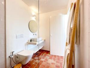 bagno bianco con servizi igienici e specchio di Casa das Piteiras nº1 - Aljezur ad Aljezur Altre 6 foto