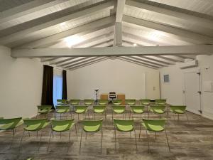 einen Konferenzraum mit einem Tisch und grünen Stühlen in der Unterkunft Ca' Maggiolo in Cinto Caomaggiore