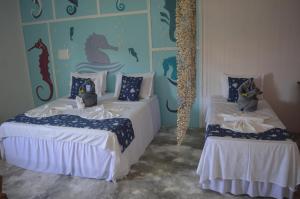 2 camas en una habitación con una pared de sirena en Pousada Vila Vovo Zilda, en Maragogi
