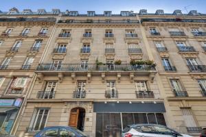budynek w Paryżu z samochodami zaparkowanymi przed nim w obiekcie Modern Stylish and Chic Apartment next to the Famous Paris Catacombs w Paryżu