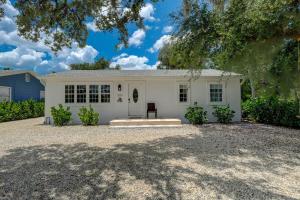a white house with a large driveway at Walk to Downtown Bonita Springs From Our Home in Bonita Springs