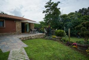 einen Hinterhof eines Hauses mit Terrasse und Gras in der Unterkunft AlmadeMencía in Pontevedra