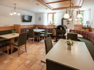 a restaurant with tables and chairs and a fireplace at Hotel B&B Martha in Brunico